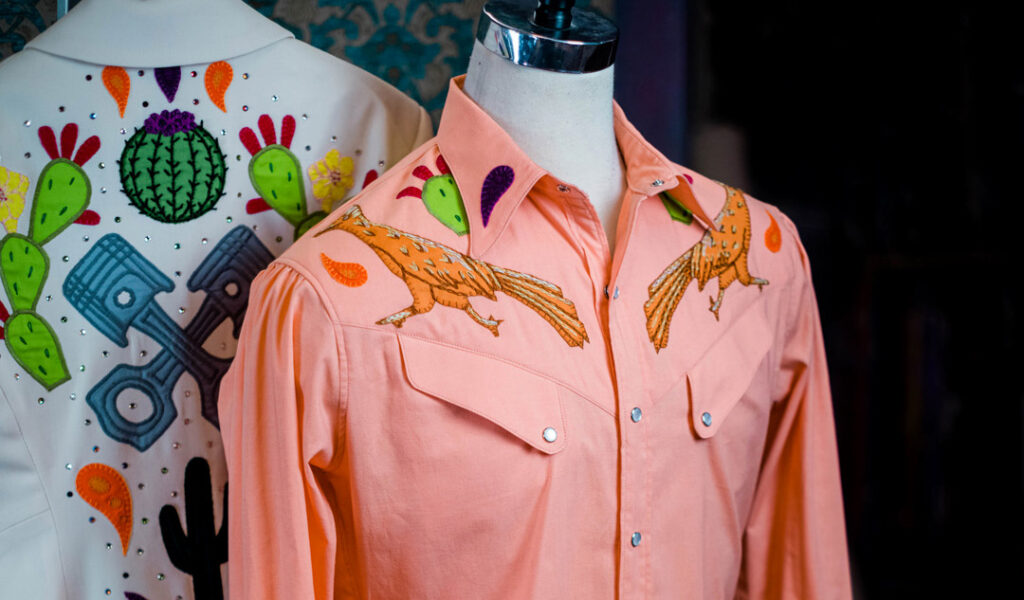 But nowhere is the unique quality of handwork more obvious than in our westernwear.  We draft all of our artwork directly onto the patterns, using a pencil, and all of the blanket-stitching and chain-stitching is done by hand, one stitch at a time, so that (unlike with modern computerized embroidery) each stitch follows the contour and direction of the stem, flower, or butterfly that we are embroidering.